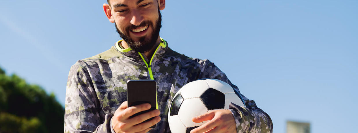 voetbal city game delft - man met bal en telefoon in handen - Dagtochten Combinatie Delft